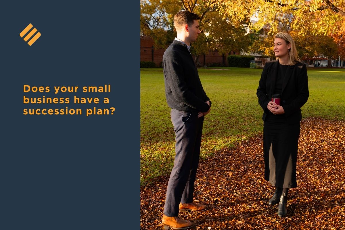 Two business professionals discussing succession planning outdoors in autumn, with the text “Does your small business have a succession plan?”