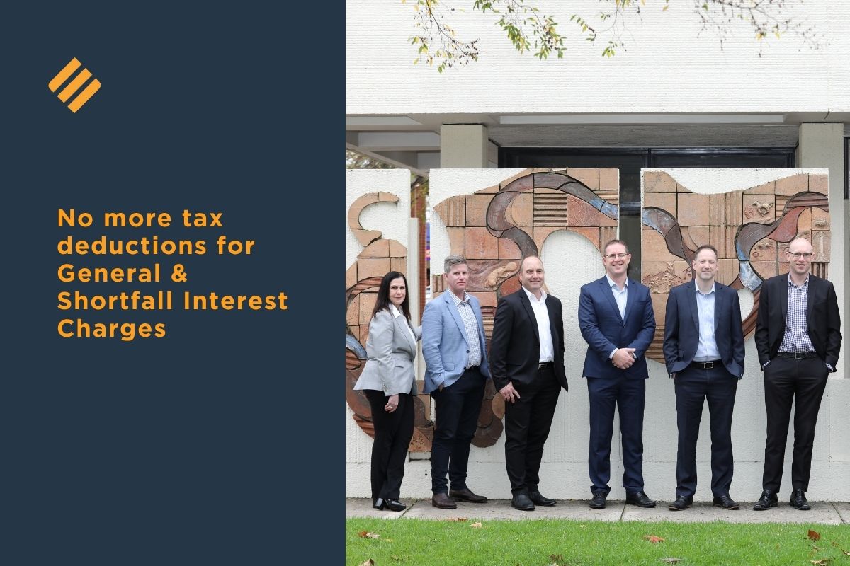 Six Johnsons MME Directors standing outside the Albury office beside a decorative wall mural, accompanying article text “No more tax deductions for General and Shortfall Interest Charges.”